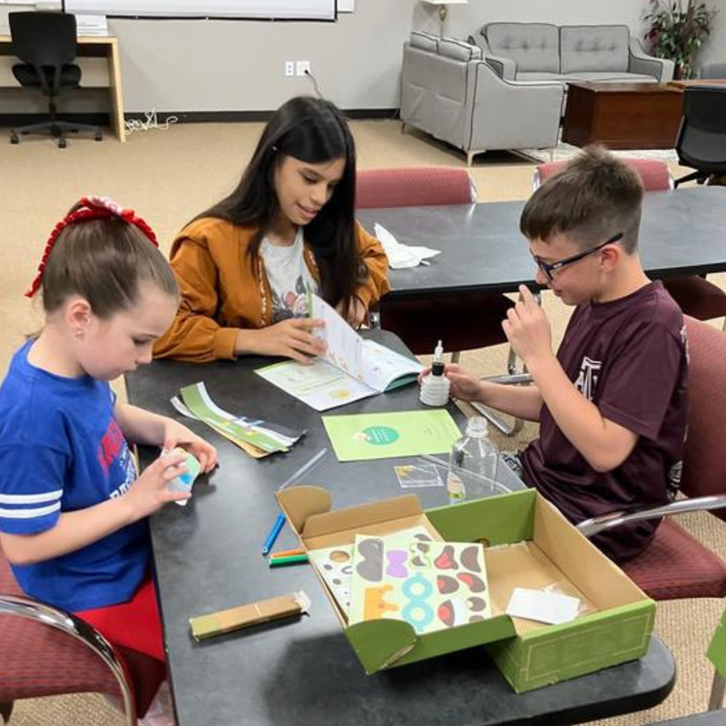 Three kids at a table working collaboratively