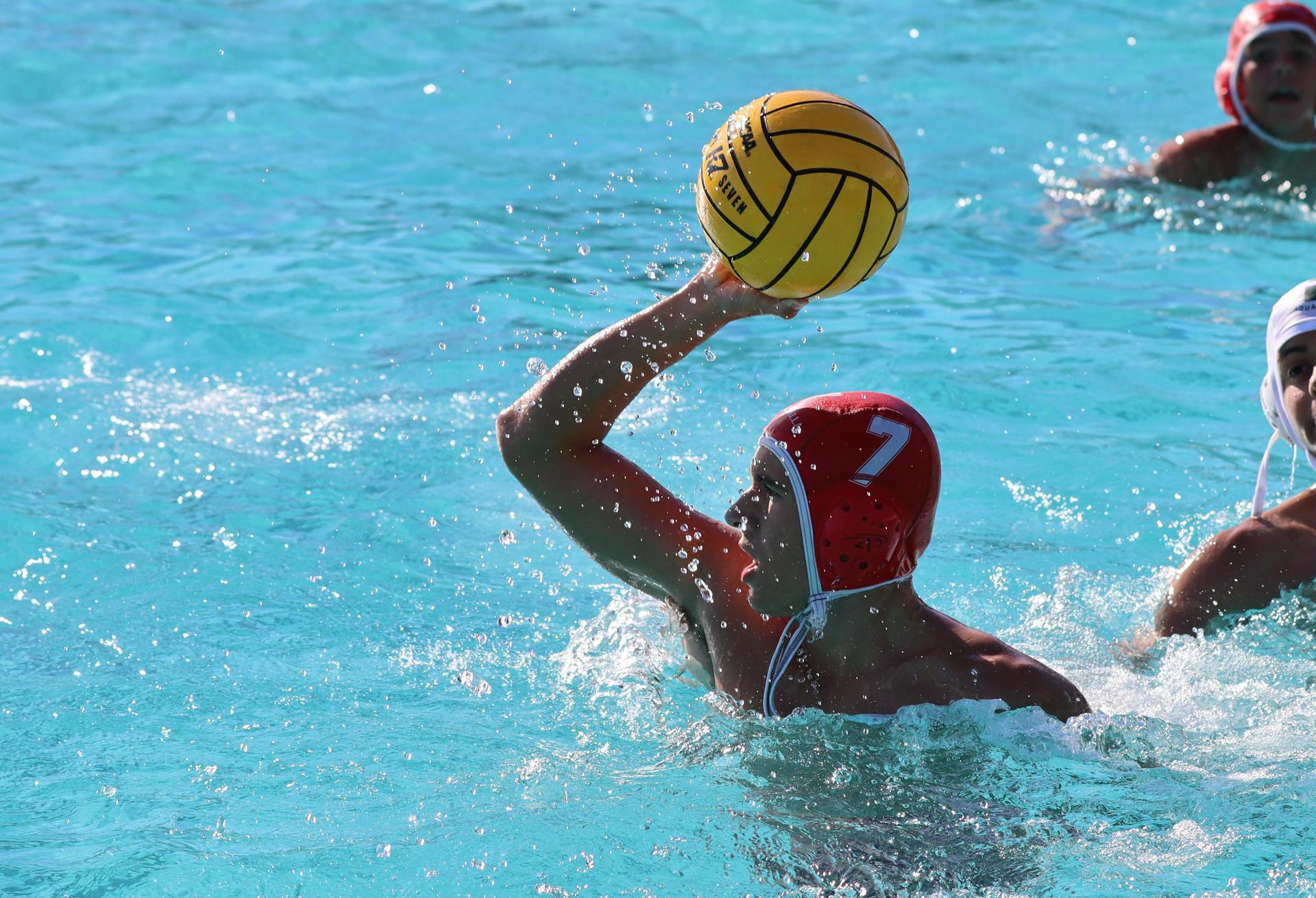 boys water polo players in action against hoover