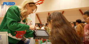 Woman shows student a tablet at annual food show