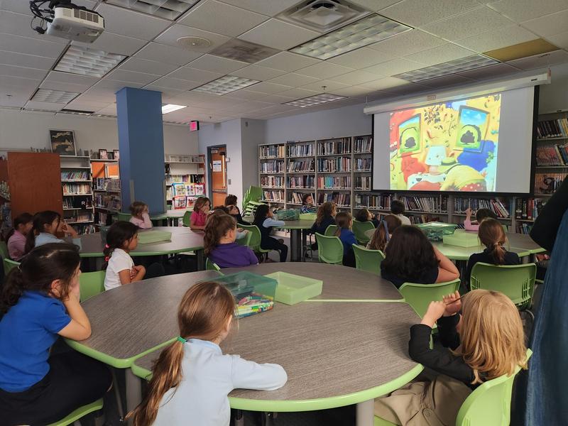 The students listen to a reading of "A Bad Case of the Stripes" by David Shannon.