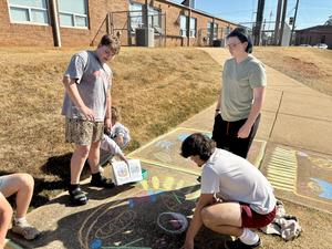 Group of students working on sidewalk art of the cell