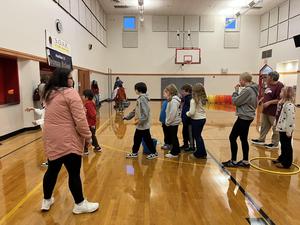 Group of children playing games in a gymnasium.
