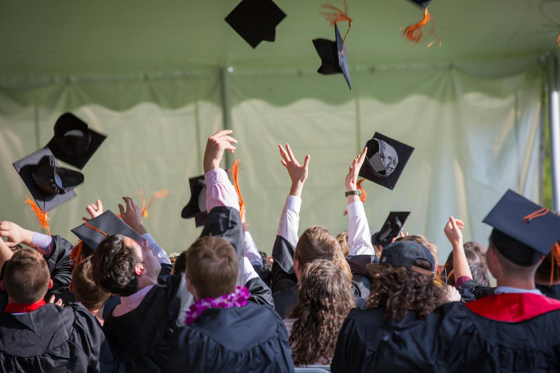 students throwing caps in the air