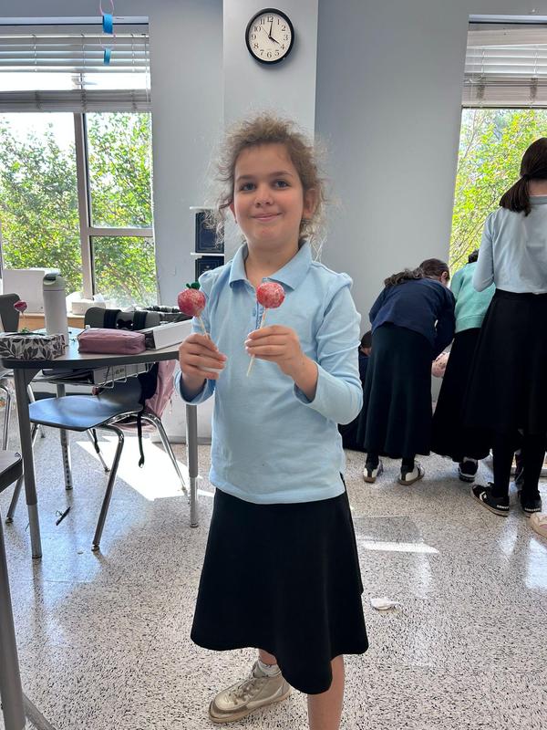 A student displaying her completed cake pop