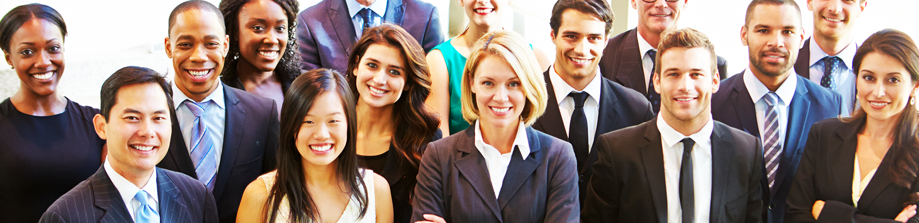 A large, diverse group of business people smiling and facing the camera.