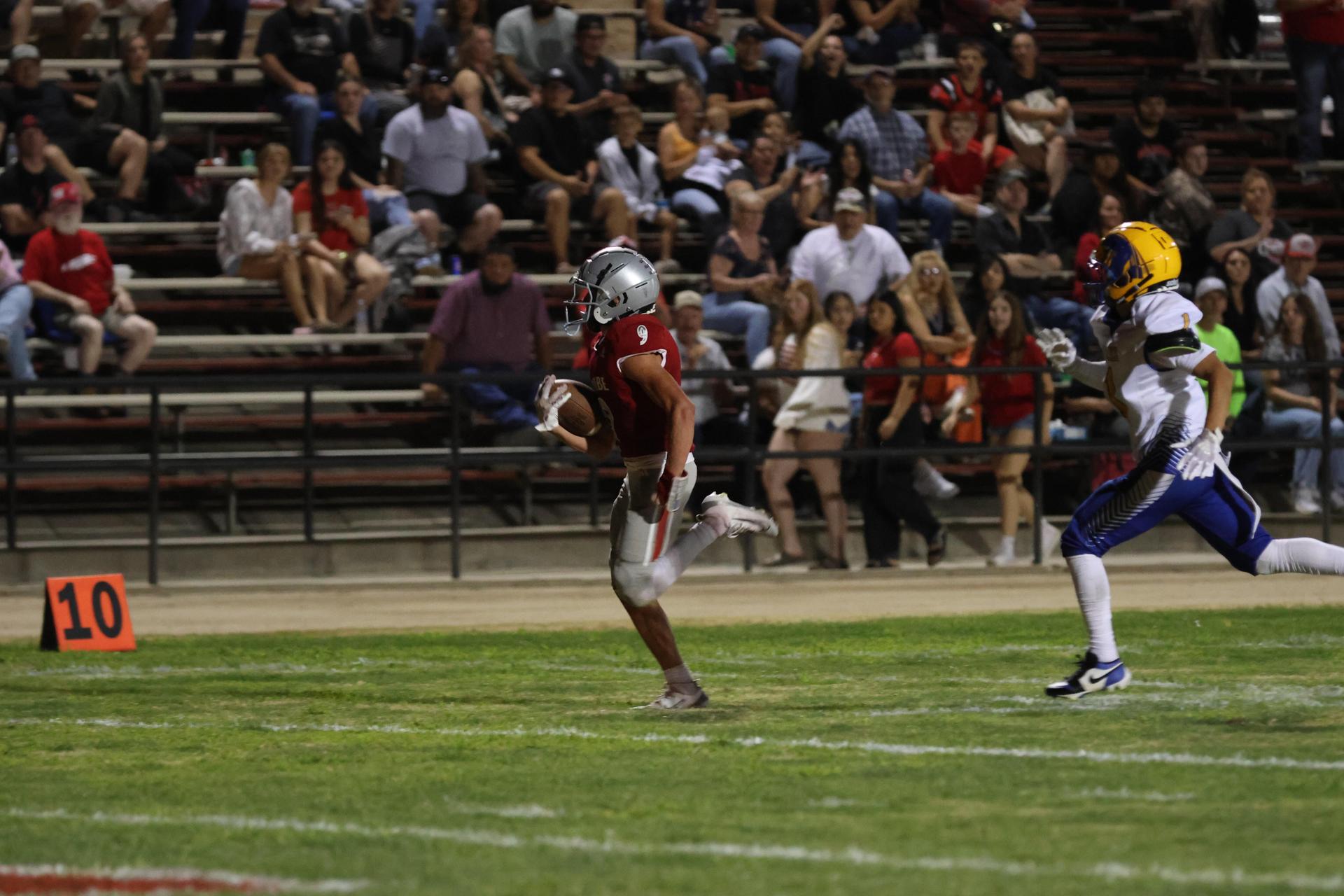 Varsity football players in action against Parlier 26