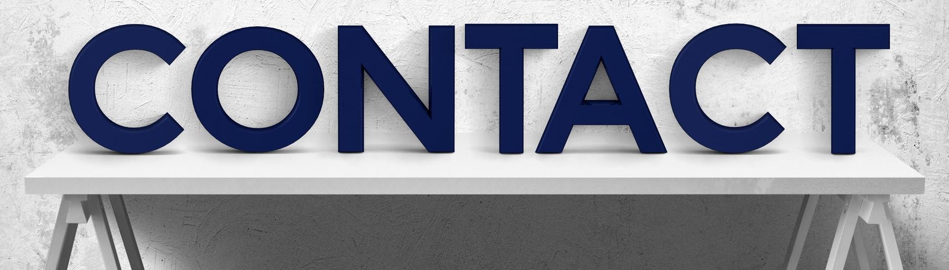 CONTACT, blue cutout letters on a white table