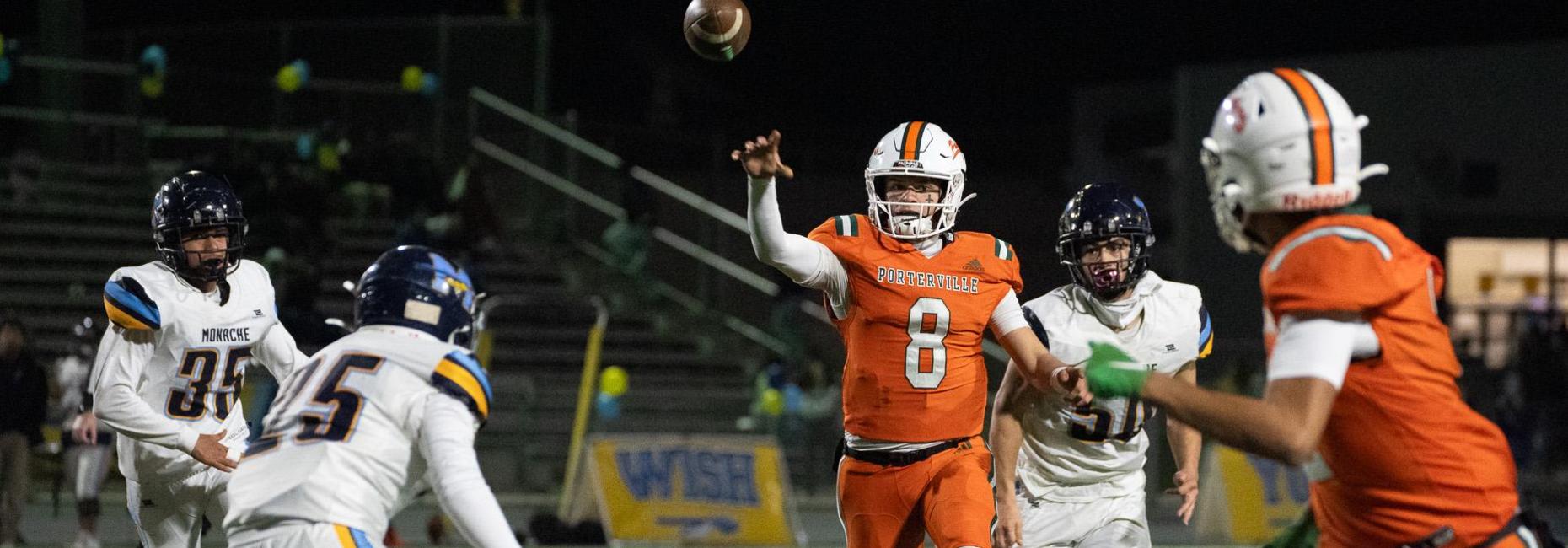 A Porterville High School quarterback throws a pass during a football game under stadium lights.