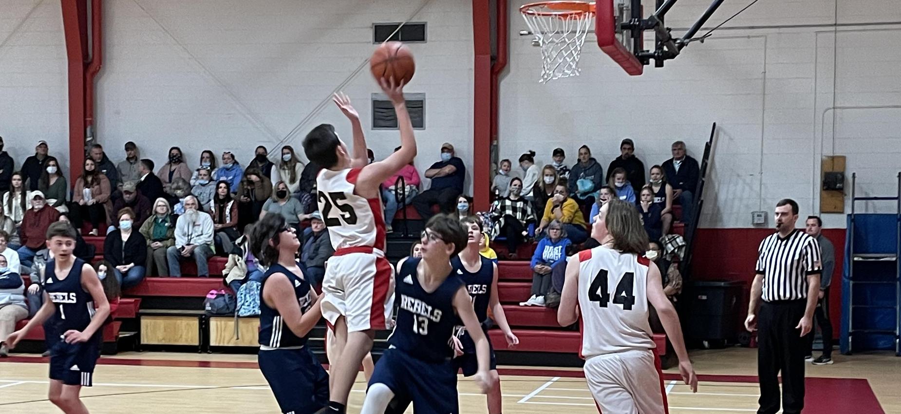 A basketball players shoots in a gym.