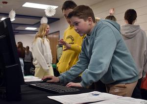 a boy using a desktop computer