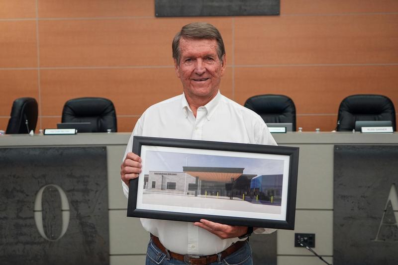 Dan Krueger holding photo of building