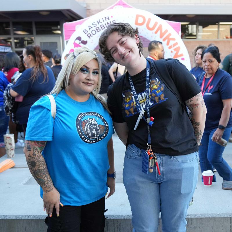 two staff members in front of Dunkin sign at Welcome Back Celebration
