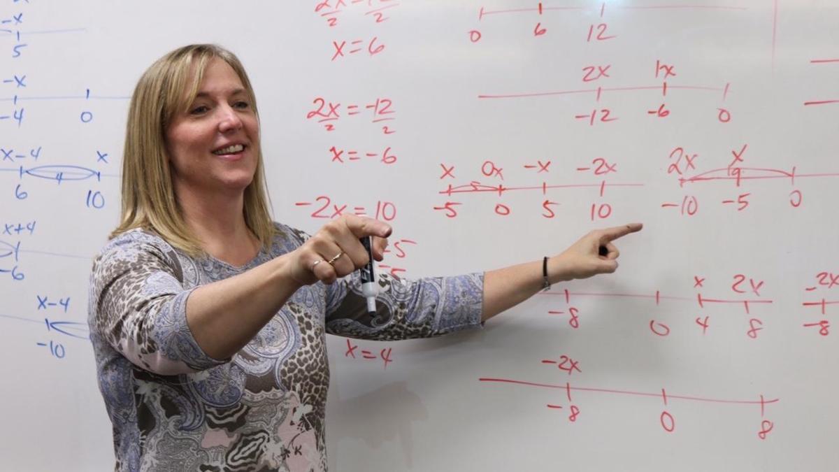 Pam Harris teaches in front of a whiteboard