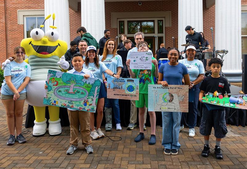 Students posing for picture with their Earth Day poster