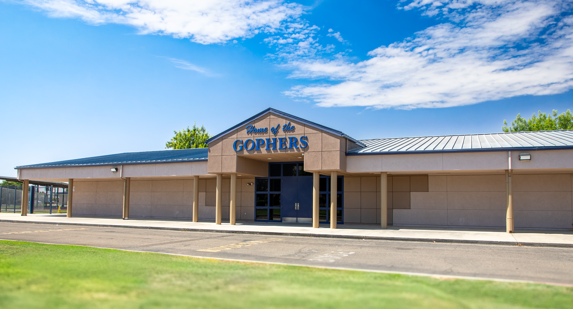 Garden Elementary School building with 'Home of the Gophers' sign under a blue sky.