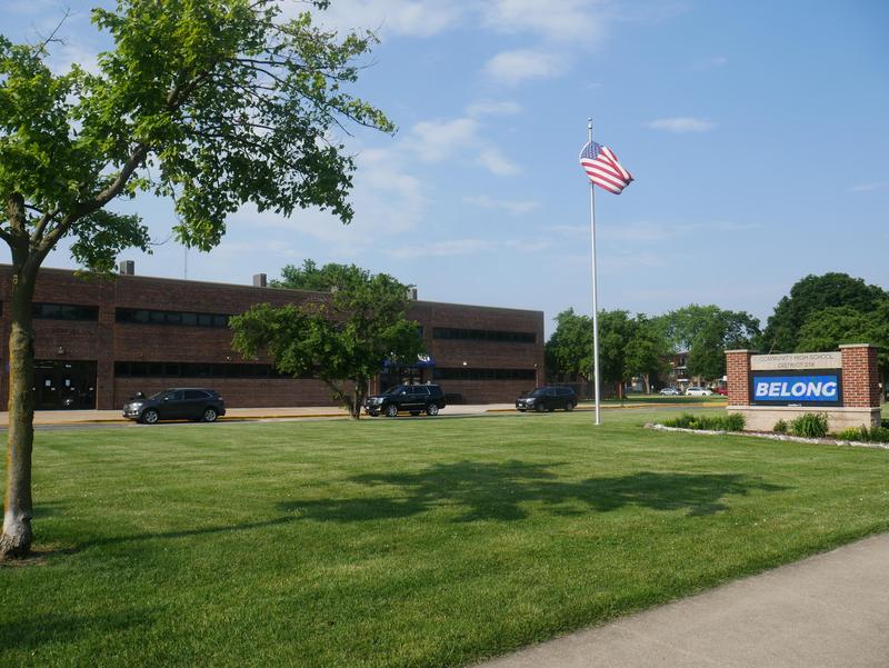 Building with marquee reading "Belong" and American flag blowing in the wind