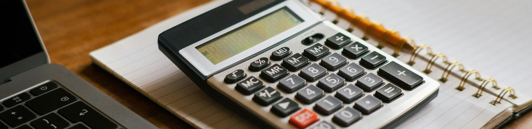 close-up photo of calculator, laptop and notebook