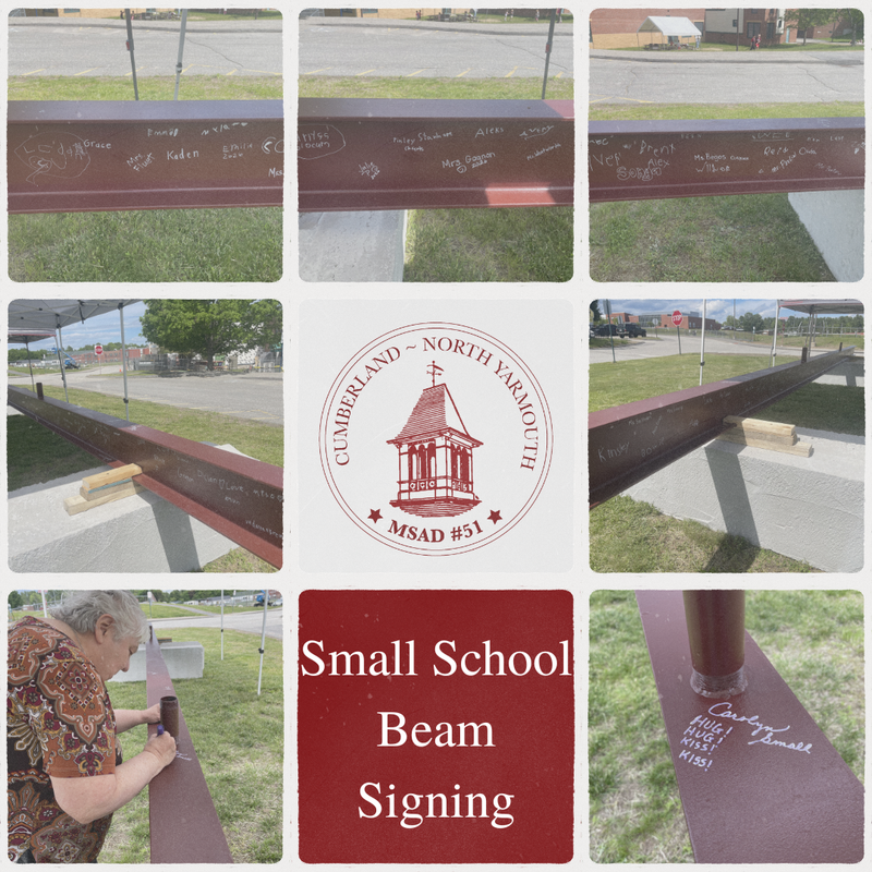 Community members signing a beam at a school event, with names and drawings visible.