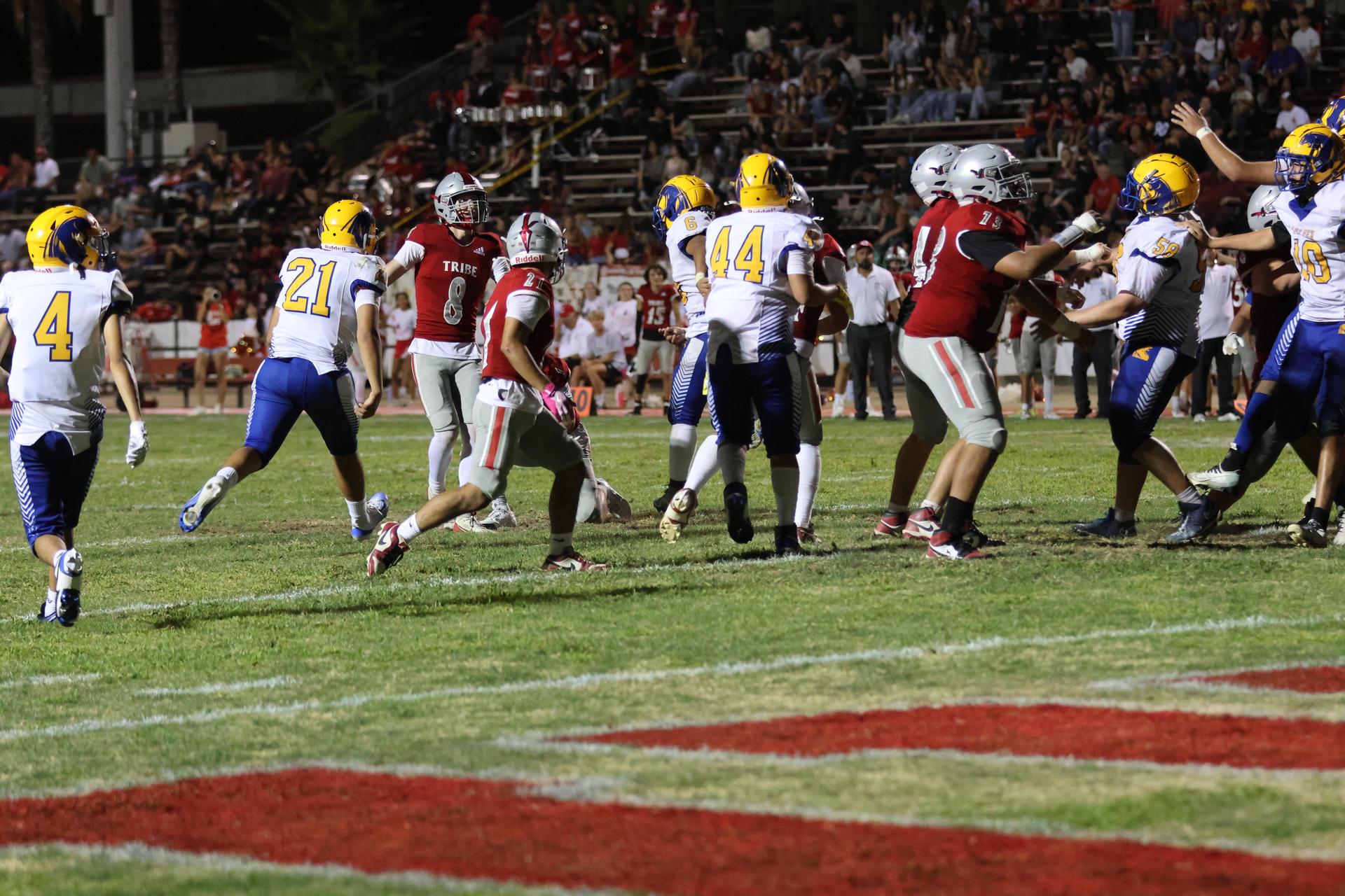 Varsity football players in action against Parlier 125