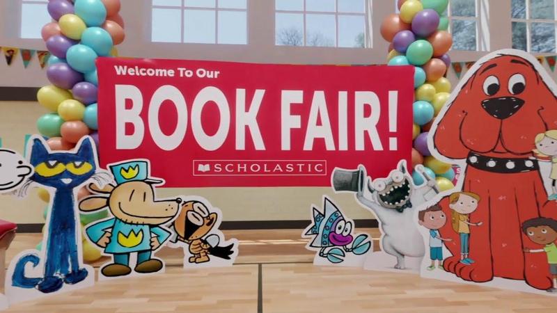 Cardboard cutouts of popular storybook characters (Pete the Cat, Clifford, and Dogman) surround filled Scholastic Book Shelves