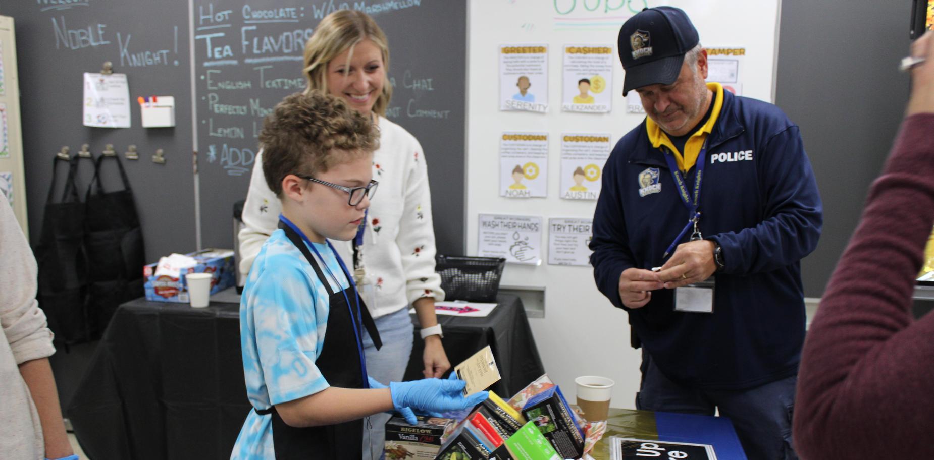 Boy handling a card while standing at a table filled with snacks.