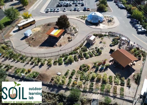 Aerial view of a garden site under construction, with the SOIL Outdoor Learning Lab logo in the bottom left.