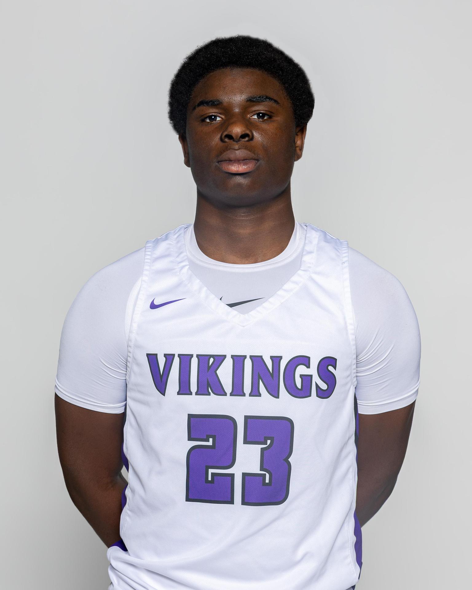 Teenage boy in a white basketball uniform with 'Vikings' and number 23.