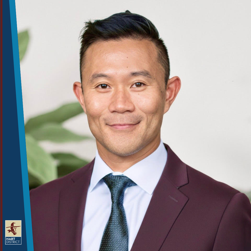 Dennis Yong, a man with dark hair in a burgundy suit smiling