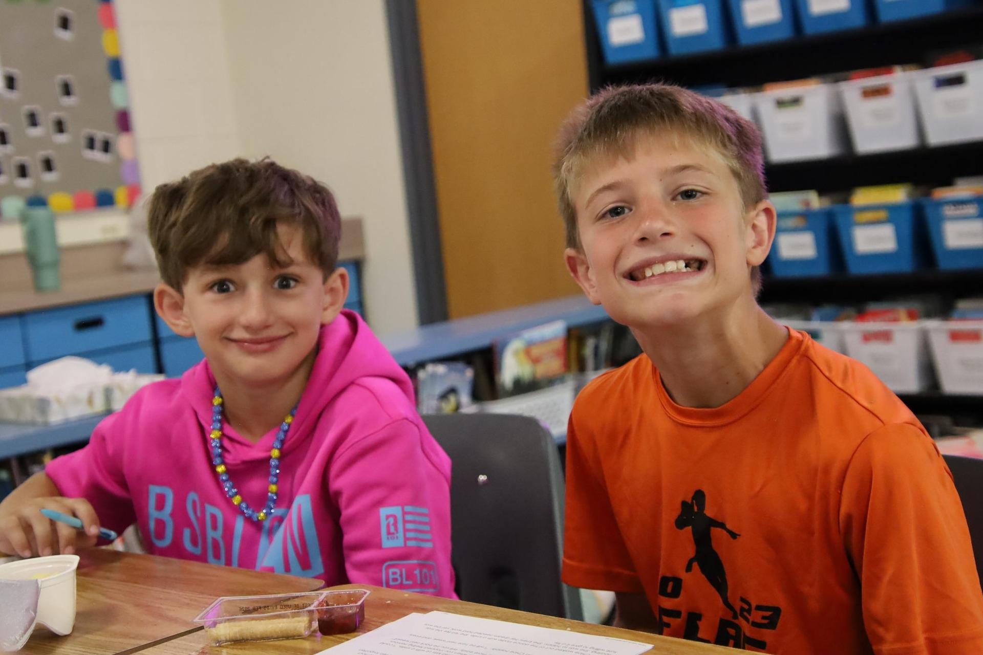 Two students smiling in a classroom