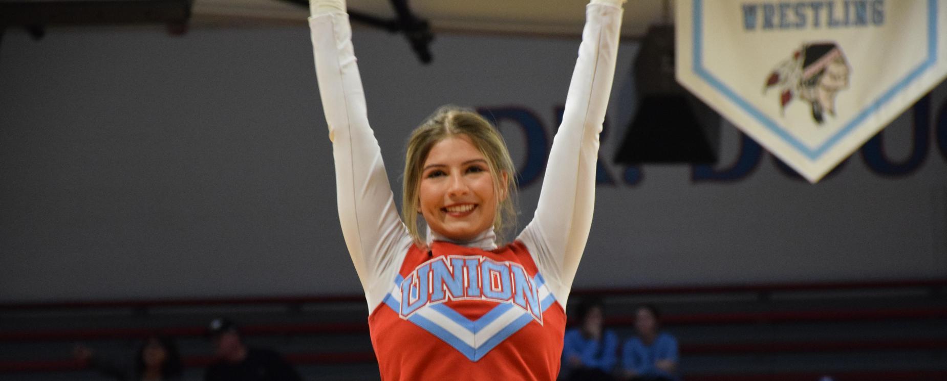 Cheerleader with arms raised
