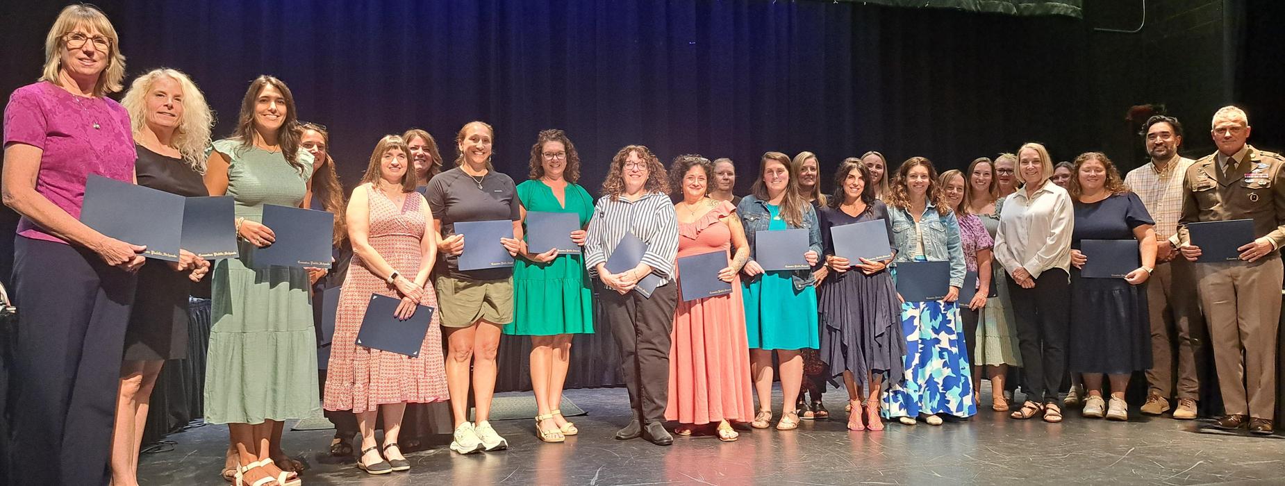 2026 Teachers of the Year pose with Senator Hanna Gallo on stage after being recognized by the School Committee.