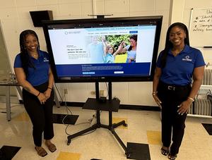 Anna and Rhonda standing by powerpoint screen