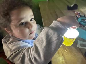 A kindergarten student basks in the glow of her star projector