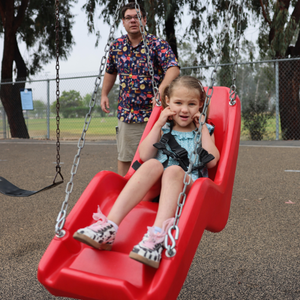 student riding adaptive swing