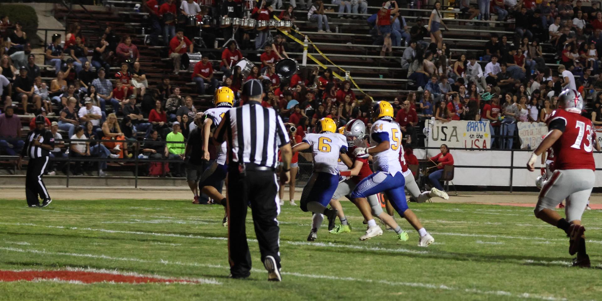 Varsity football players in action against Parlier 33