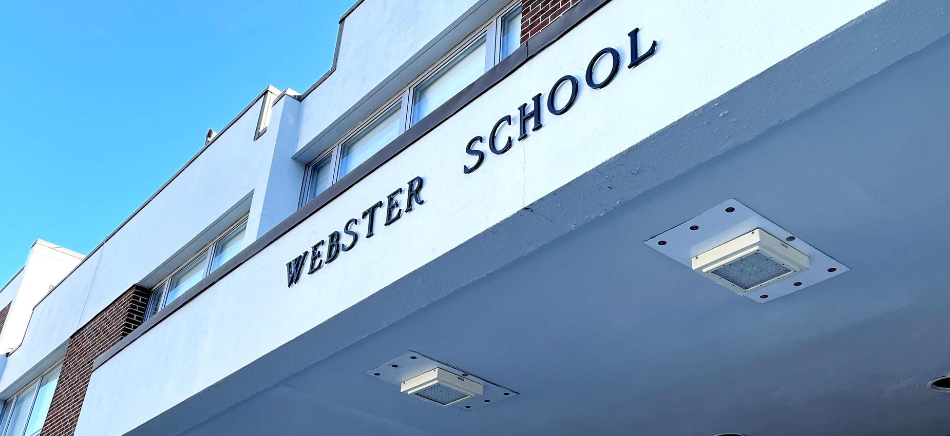 Facade of Webster School with clear blue sky above.