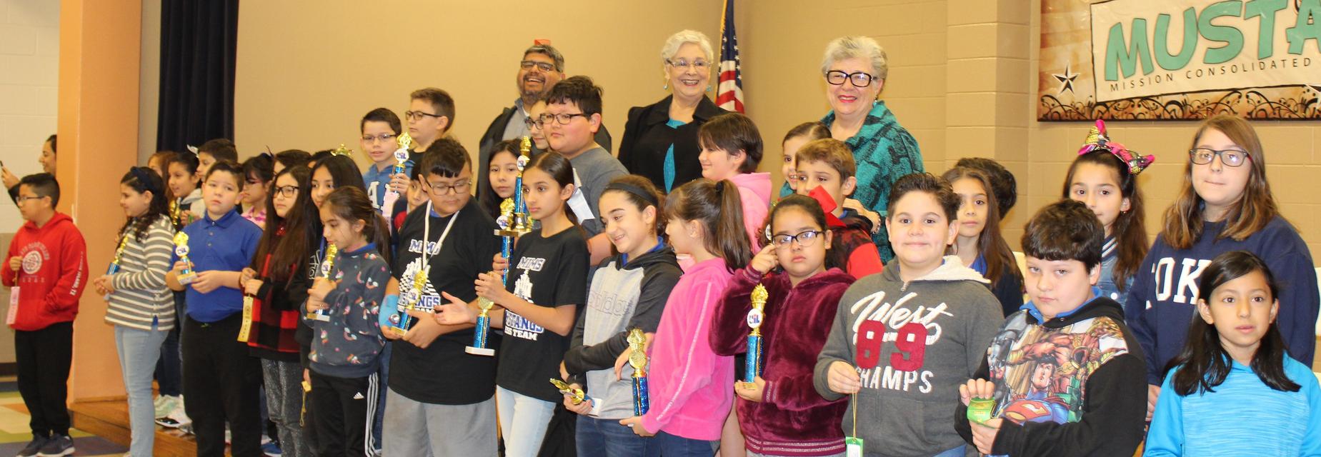 students with trophies and school board members