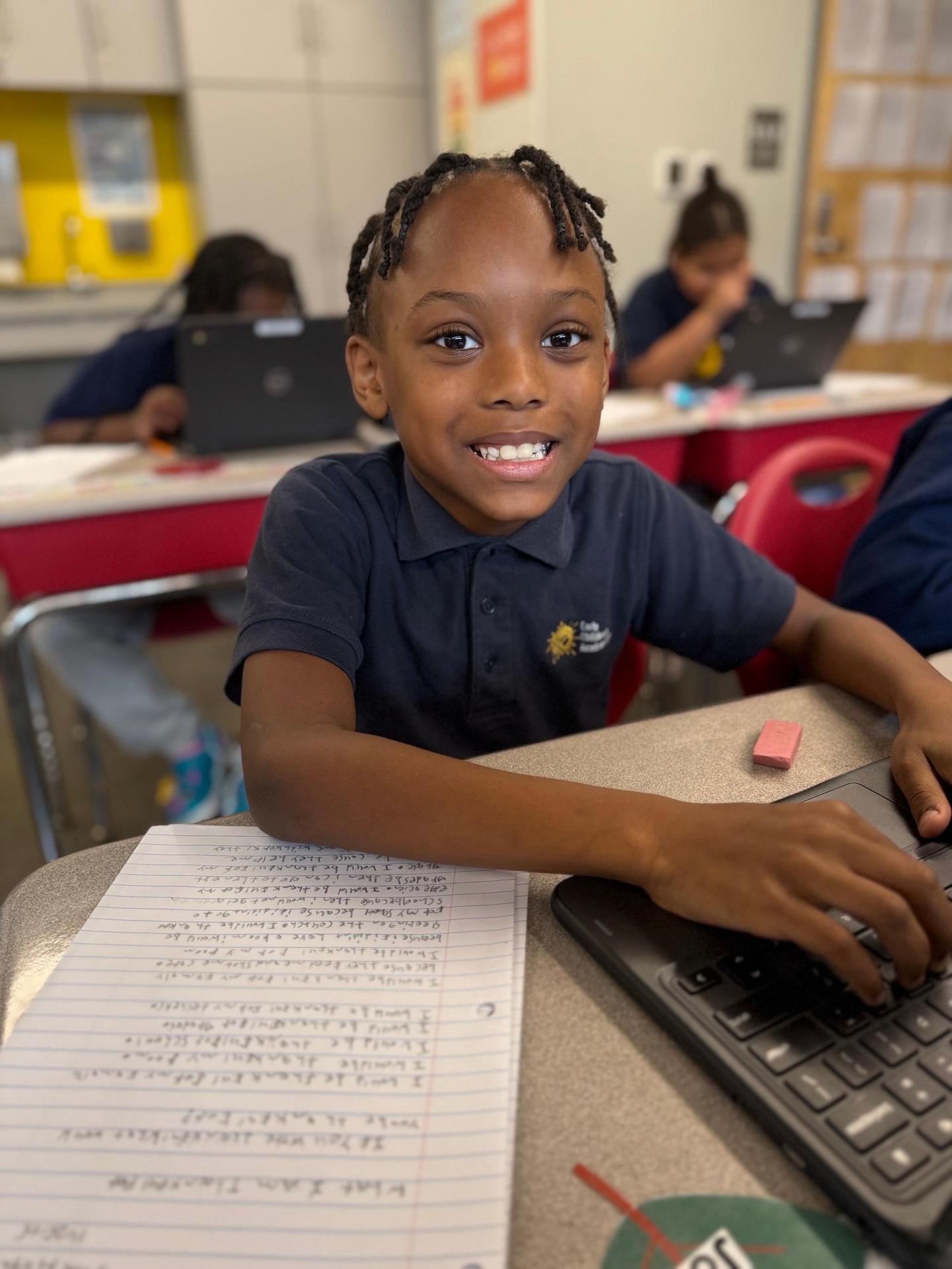 Boy student typing on laptop