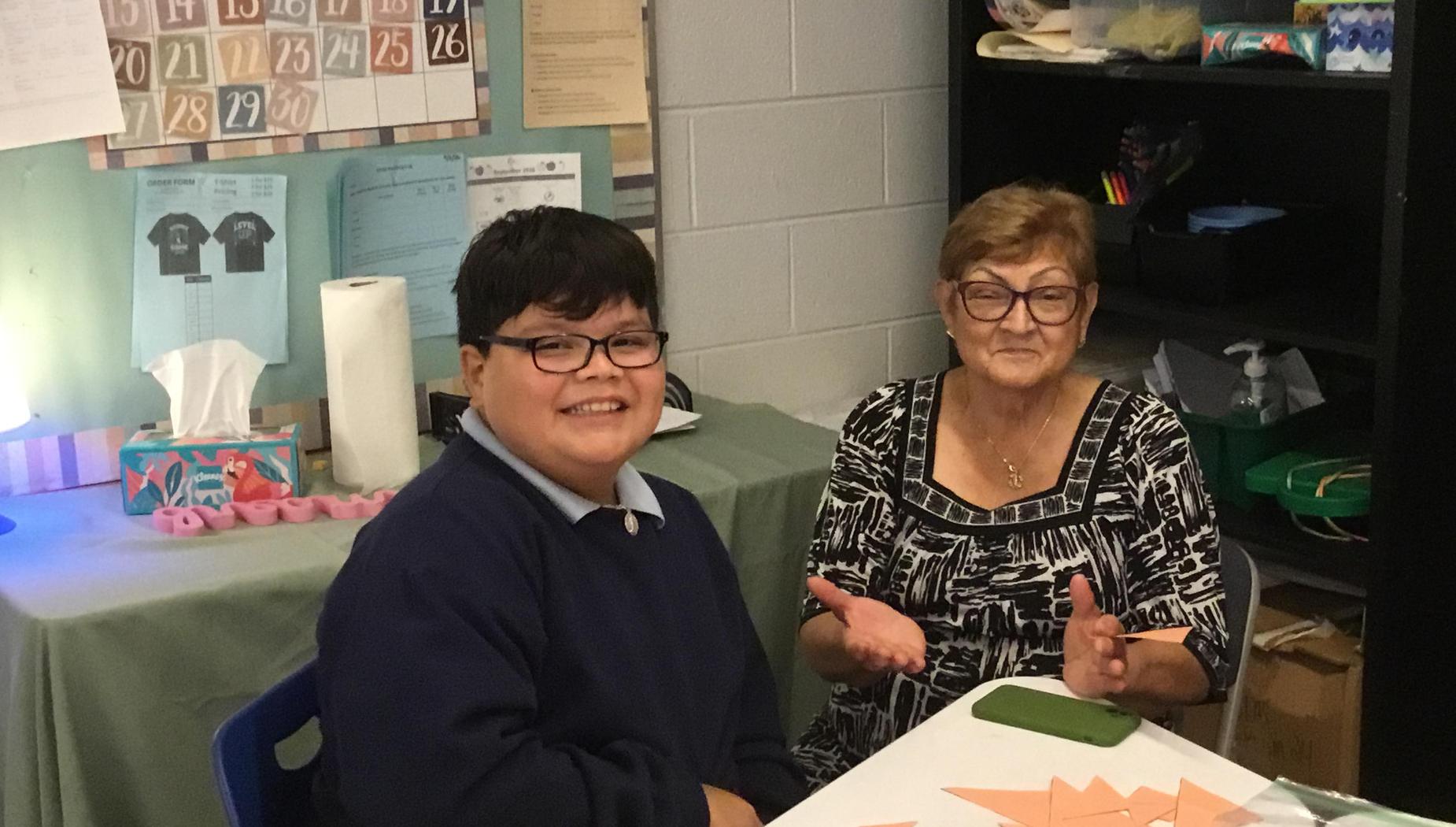 Two people smiling at a table, engaged in a conversation during a craft activity.