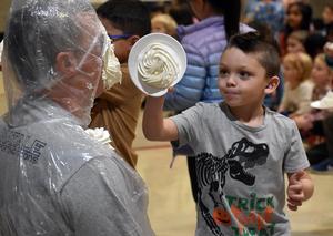 a student tossing a pie into a teacher's face