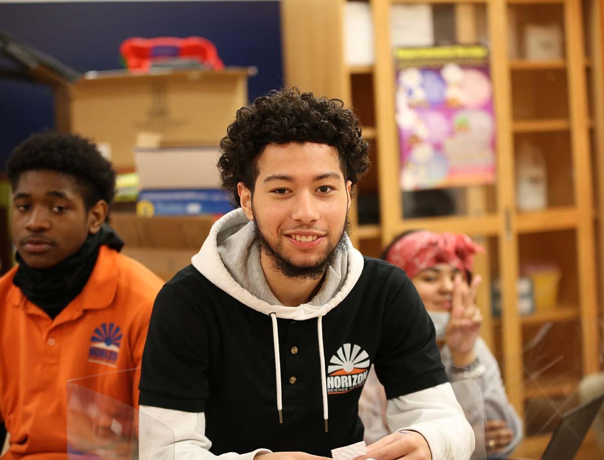 High school student smiling in a classroom.