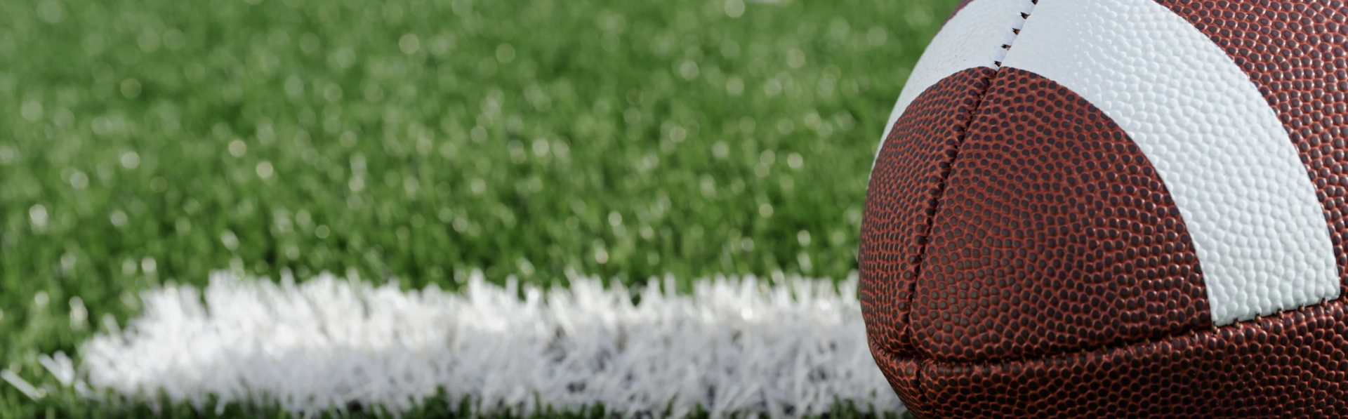 A football on a green turf field