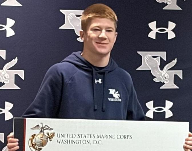 Carsten receives a GIANT scholarship check from the Marine Corps.