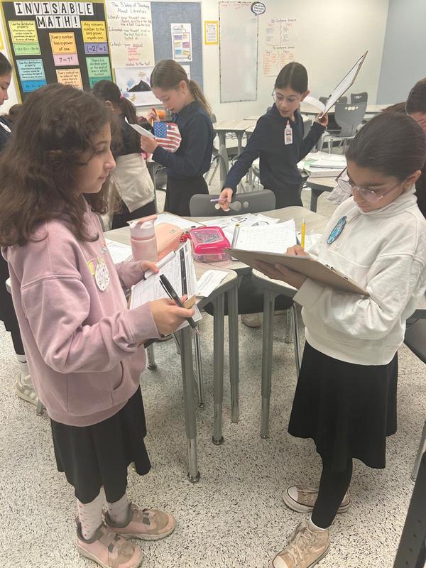 Two girls work together to gather clues at the mystery theater