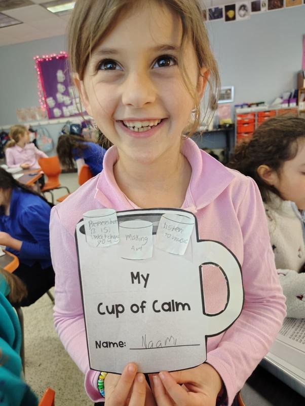 A second grade student displays her cup of calm.