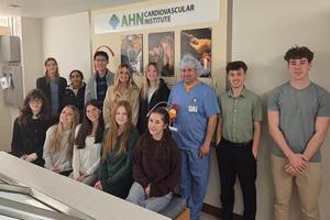 A group of students observes the surgery from the observation area
