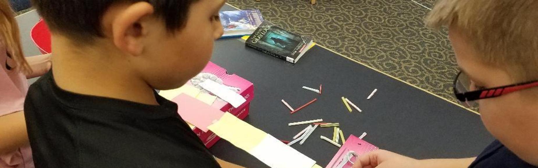 Student cutting construction paper picture