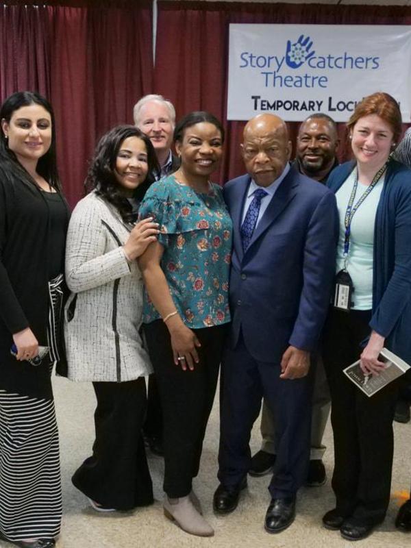 Group photo including John Lewis and several individuals in a theater setting.