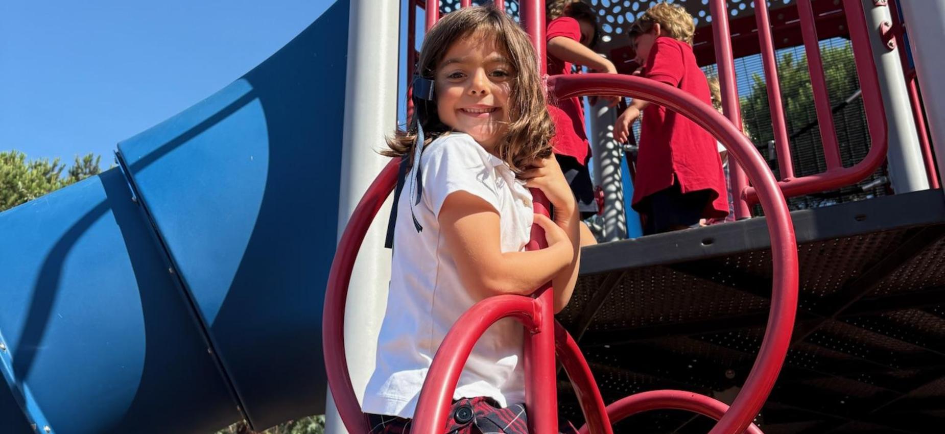 Kindergarten student climbing on the playground