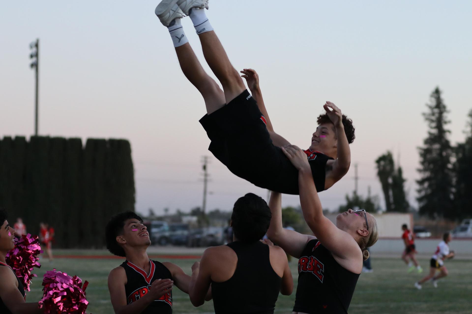 players, cheerleaders, and officials preparing for the powderpuff football game